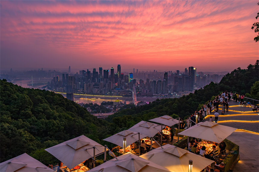 初夏时节，重庆市南岸区南山夜景火锅公园，市民品火锅美味看山城夜景。郭旭摄