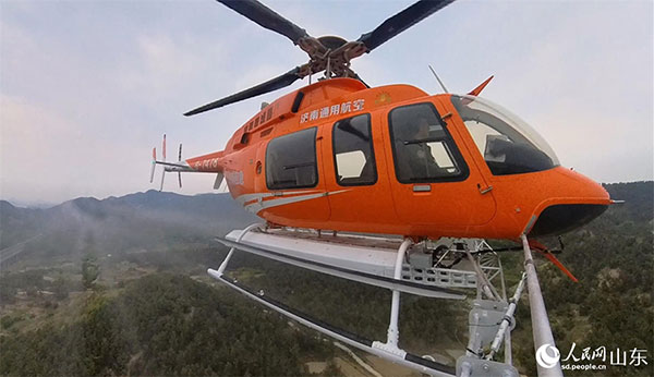 正在执行飞防作业的直升机。人民网记者 公雪摄